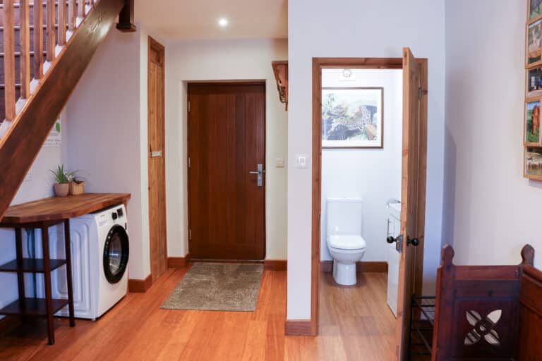 Entrance hallway with a staircase, washing machine and doors to the rooms