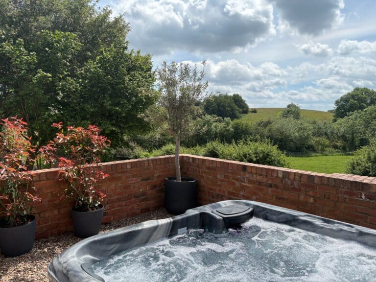 Private hot tub overlooking green fields and trees